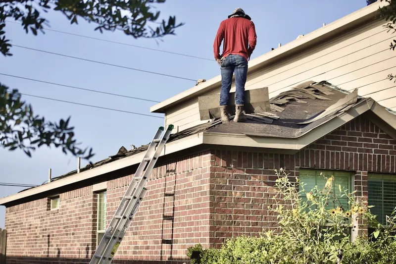 Professional roofer working on a residential roof in Biola Junction